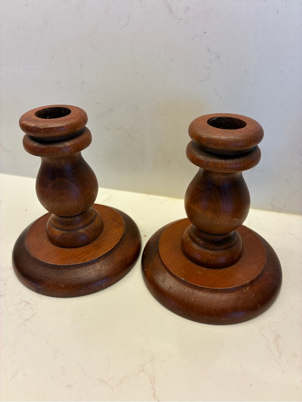 Pair of vintage turned-wood candlestick holders in a warm brown finish.